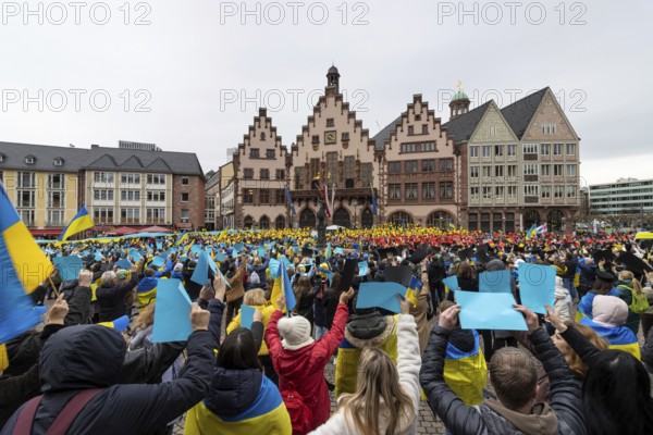 On the occasion of the war in Ukraine, which will last exactly one year on 24 February 2023, thousands of people gathered in Frankfurt am Main for a peace demonstration. On the Römerberg, participants held leaves in the colours black, red, yellow and blue in the air, creating a huge image of Ukrainian and German national flags. The Russian war of aggression on Ukraine began on 24.02.2022., Römerberg, Frankfurt am Main, Hesse, Germany