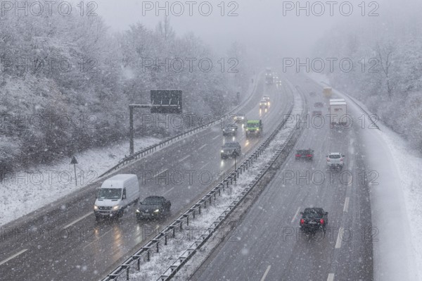 Snow-covered motorway with moving vehicles and snow-covered trees on the roadside, Winnenden, Baden-Württemberg, Germany