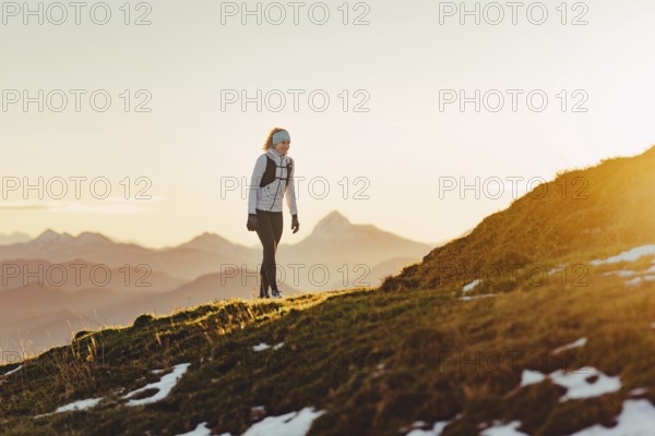 Trail running in autumn on the Jochberg on Lake Walchensee against the wonderful backdrop of the Alps, Bavaria, Germany