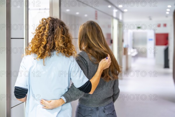 Rear view of a nurse accompanies a patient to the consultation in the hospital