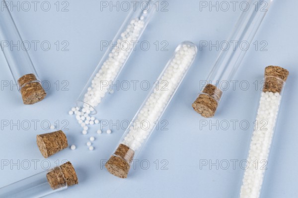 Test tubes with white globules and corks spread out on a blue background