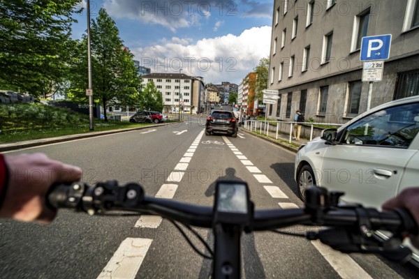Cycling in the city, city centre road, car blocking cycle lane traffic in both directions, cyclist perspective, Essen, North Rhine-Westphalia, Germany