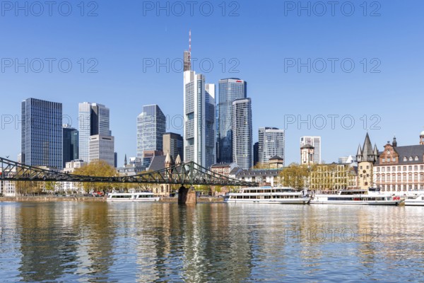 Frankfurt skyline skyscrapers with banks on the river Main with excursion boats and Eiserner Steg in Frankfurt, Germany