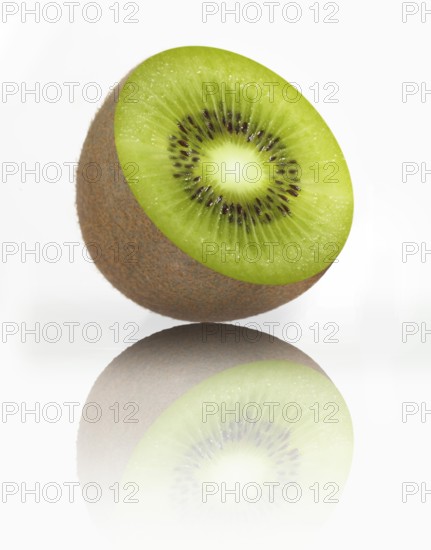 Half a kiwi, kiwi fruit, Chinese gooseberry (Actinidia deliciosa) against a white background, studio photograph