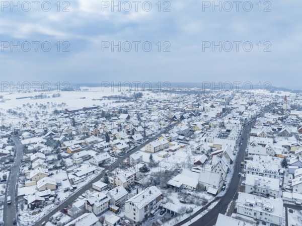 Overview of snow-covered town under cloudy sky, Deckenpfronn, Böblingen district, Germany