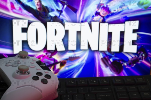 Dhaka, Bangladesh- 12 June 2025: Gaming setup with a controller and keyboard in front of a Fortnite screen