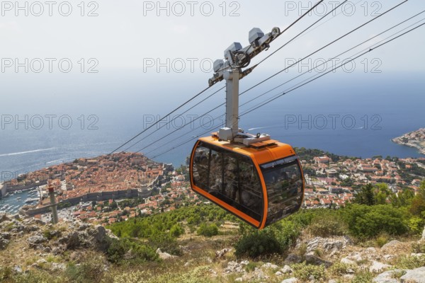 High angle view of cable car transporting tourists from Dubrovnik city center to top of Mount Srd in late summer, Croatia