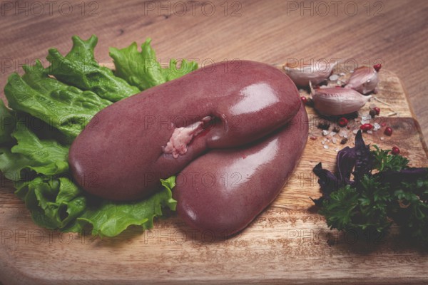 Raw pork kidneys, on a chopping board, close-up, top view, no people