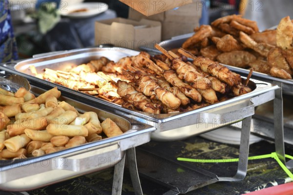 Fried Thai street food like spring rolls and chicken skewers