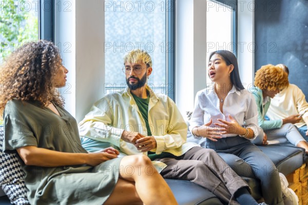 Side view of three coworkers chilling and talking in a comfortable sofa