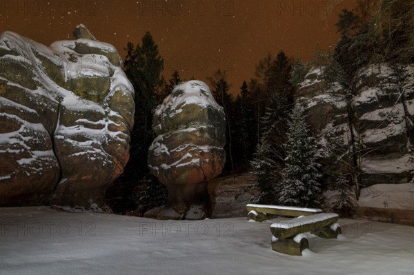 Snow-covered natural monument Kelchsteine at night and snowfall, Oybin, Zittau Mountains, Saxony, Germany
