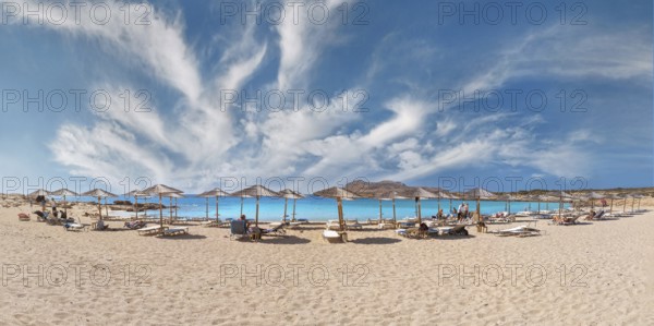 Diakoftis extensive sandy beach with parasols and sun loungers under a clear blue sky, Diakoftis beach, Karpathos, Greece