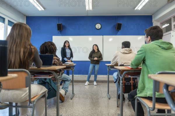 Confident young woman giving a presentation to her classmates and teacher in a modern university classroom