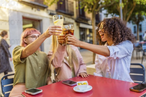 Happy three happy deverse woman toasting in an outdoor bar