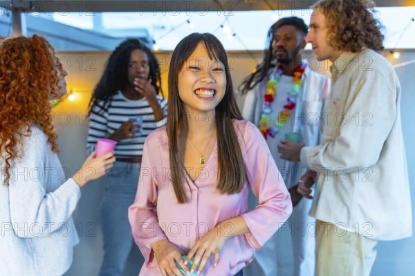 Beauty cheerful chinese woman smiling standing in a roof party with multi-ethnic friends