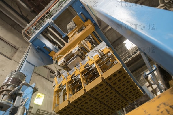 Brickyard. Bottom view of production machine with bricks