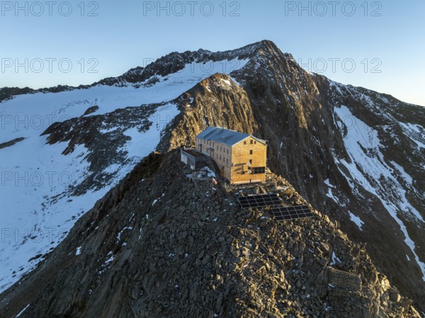 Atmospheric sunrise in a picturesque mountain landscape, alpenglow, aerial view, mountain hut Becherhaus at the summit Becher and glacier Übeltalferner, Stubai Alps, South Tyrol, Italy