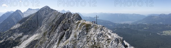 Aerial view, Alpine panorama, hikers at the summit cross, Westliche Wettersteinspitze, Wetterstein Mountains, Bavaria, Germany