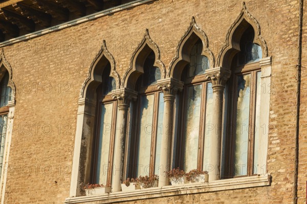 Windows of an old house on 'Campo santa margherita' town square in Venice on a sunny day in winter, Italy