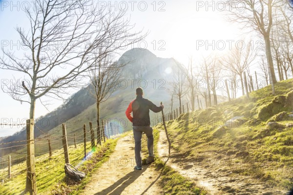 A man climbing Mount Ernio or Hernio in Gipuzkoa at sunset, Basque Country