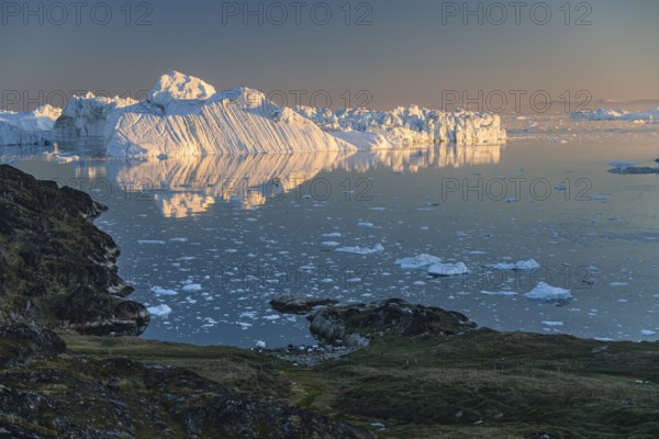 Icebergs and ice floes reflected in the water, summer, midnight sun, Jakobshavn glacier and ice fjord, Ilulissat Kangerlua, Disko Bay, West Greenland, Greenland
