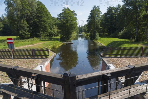 A wooden lock opens onto a quiet river surrounded by trees, Tartak Lock, Augustow Canal, Augustowski Canal, Suwalki, Podlaskie, Podlaskie, Poland