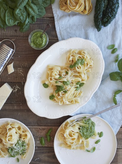 Green Tagliatelle pasta with spinach and kale pesto beside parmesan cheese. Traditional Italian meal