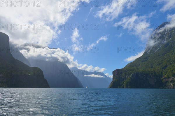 Majestic fjord with dominant mountains and few clouds under a blue sky, summer, Milford Sound, Te Anau, Fiordland National Park, South Island, New Zealand