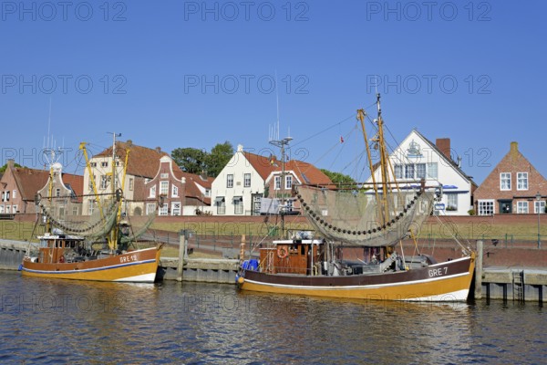 Crab cutter in the harbour in front of historic buildings, blue sky, Greetsiel, North Sea, Lower Saxony, Germany