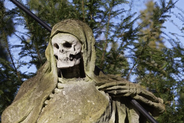 Grim Reaper, allegory of death with hourglass and scythe, sculpture at the Melaten Cemetery, Cologne, North Rhine-Westphalia, Germany