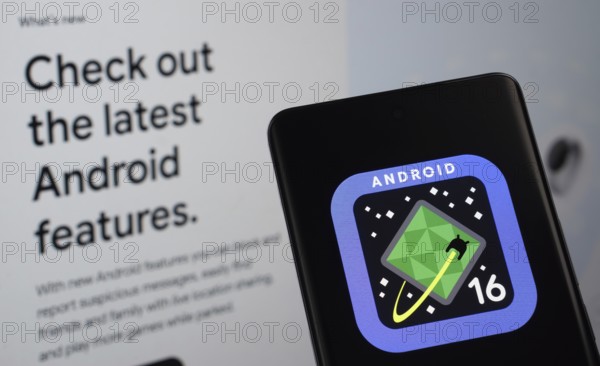 The logo of the Android 16 is displayed on a smartphone screen, with the android website visible on a computer screen in the background