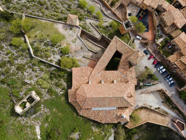 An aerial view of a historic fortress with tiled roofs and surrounding buildings on stony terrain, aerial view, collegiate church on the hill, Colegiata de Santa María la Mayor, Alquézar, Alquezar, Huesca, Aragón, Aragon, Pyrenees, Spain