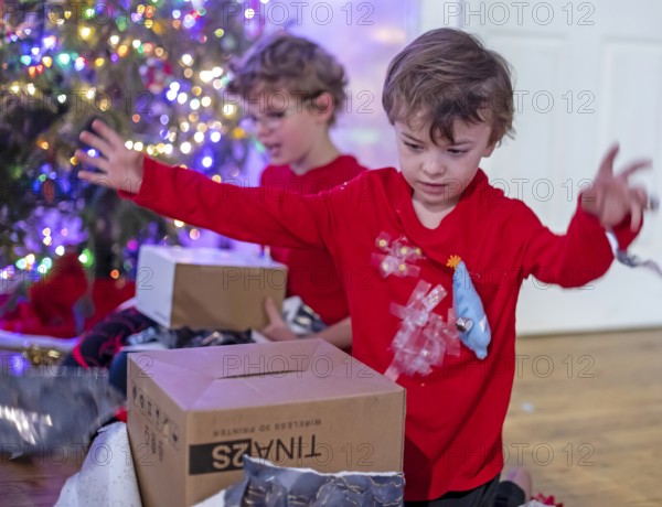 Denver, Colorado - Hendrix Hjermstad, 6, (right) and his brother Adam Hjermstad Jr., 10, open Christmas presents on Christmas morning