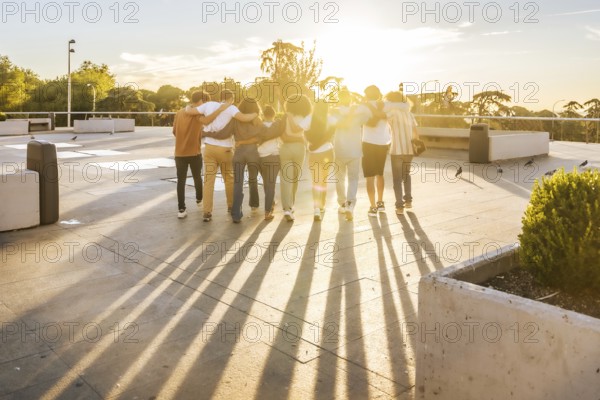 Rays of the sunset illuminating a group of friends having fun strolling together at city