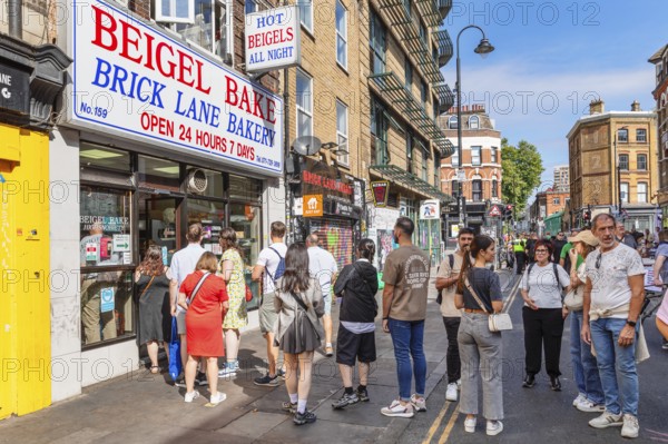 Customers queuing outside a bagel shop, Brick Lane Market, East End, London, England, United Kingdom, London, South England, United Kingdom
