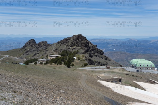 Barren mountains with green dome-like buildings and a wide view over the mountain landscape, on the left Albergue Universitario, on the right Capitan Cobo de Guardia Civil base, Hoya de la Mora, hollow of the Maurin, Güéjar Sierra, Güejar, Sierra Nevada, Andalusia, Spain