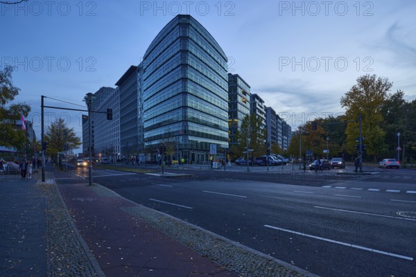 Junction of Lennéstraße with Ebertstraße and glass facade of a commercial building at blue hour in Berlin, capital city, independent city, federal state Berlin, Germany