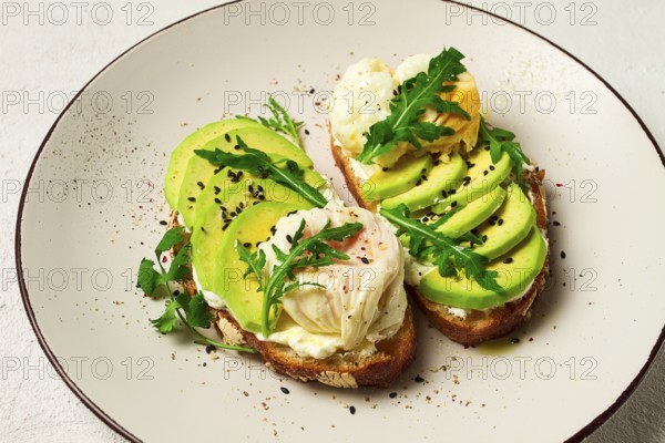 Sandwich with cream cheese, sliced avocado and boiled egg, arugula, on grainy bread, homemade, breakfast, no people