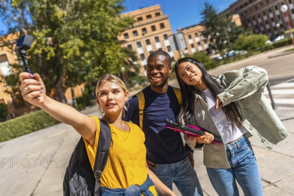 Multi-ethnic university students streaming online with small digital camera standing on the campus