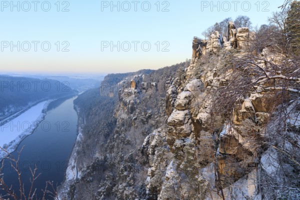 Kanapee viewpoint at the Bastei into the snow-covered Elbe valley with sandstone cliffs such as the Wartturm and the floating viewing platform of the Basteiaussicht, Saxon Switzerland, Saxony, Germany