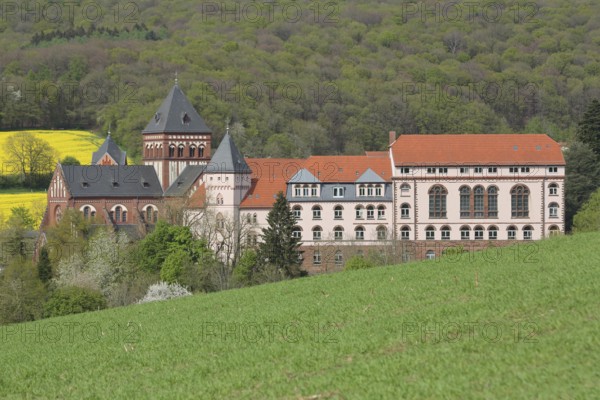 View of mission house church built in 1905, landscape, forest, rape field, mission house, Arnold-Janssen-Gymnasium, Sankt Wendel, Saarland, Germany