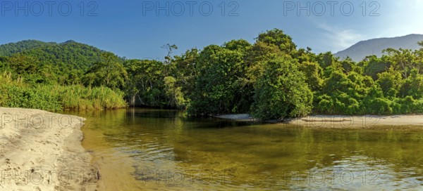 River through the rainforest flowing into Castelhaos beach on Ilhabela island in Sao Paulo, Brazil