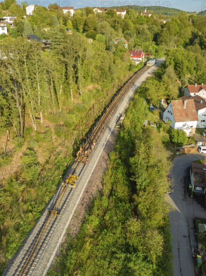 Railway tracks run through a village surrounded by trees, track construction, rail delivery for Hermann Hessebahn, Calw, Black Forest, Germany