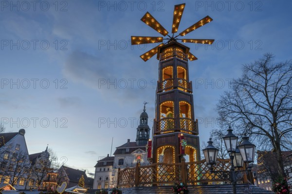 Large Christmas pyramid at the Christmas market at dusk, behind the historic town hall, Lüneburg, Lower Saxony, Germany