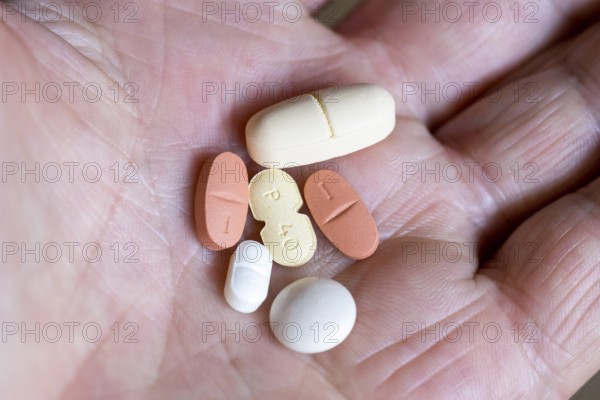 Hand holds various tablets, medicines
