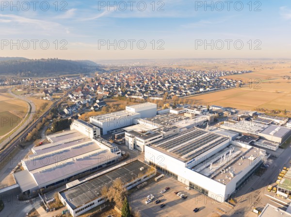 Aerial view of factory buildings on the outskirts near fields under a blue sky, Nufringen, Germany