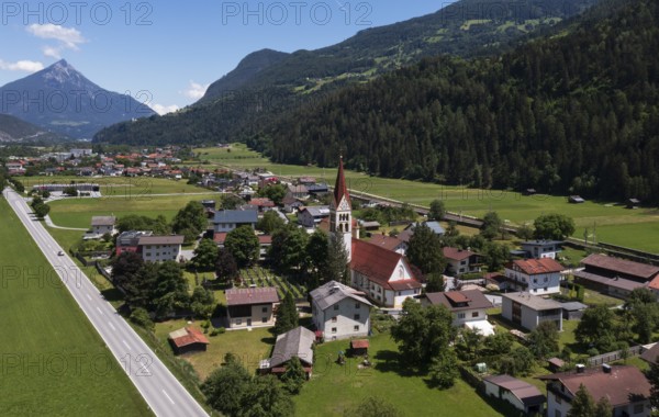 Drone shot, view of village with parish church, Schönwies, Oberinntal, Tyrol, Austria