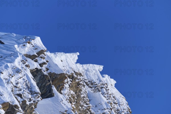 Snow-covered mountain peak with snow cornices under a clear blue sky, Gemmi Pass, Plattenhörner, Leukerbad, Leuk, Valais, Switzerland