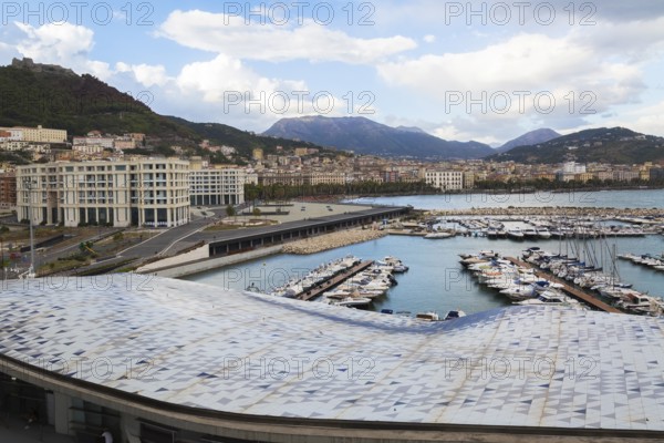 High angle view of roof of Salerno cruise port terminal building by Zaha Hadid and marina with luxurious private yachts, Port of Salerno, Campania region, Italy