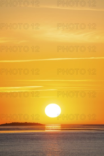 Picturesque, golden, magnificently beautiful sunset over the sea, Langlütjen II island far away, sun ball just above the horizon, orange glowing cloudless sky, wide sea in soft colours, calm atmosphere, radiant light mood, mouth of the Weser into the North Sea, Outer Weser, Bremerhaven, Land Bremen, Germany